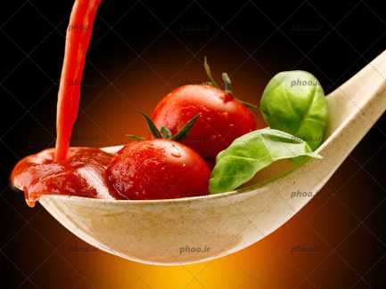عکس سبزیجات و گوجه و سس داخل قاشق از زاویه نزدیک و زمینه قرمز