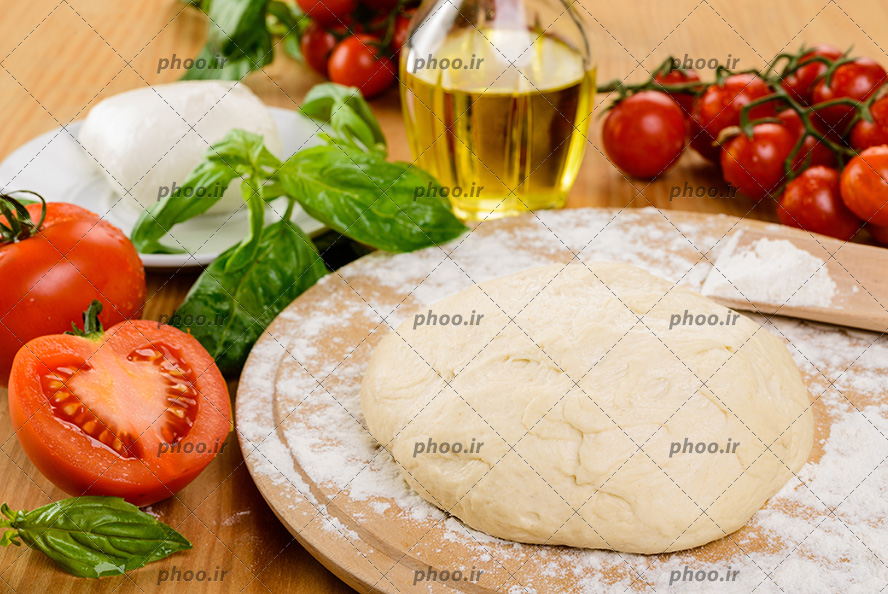 عکس خمیر پیتزا و مواد اولیه پیتزا و گوجه ها