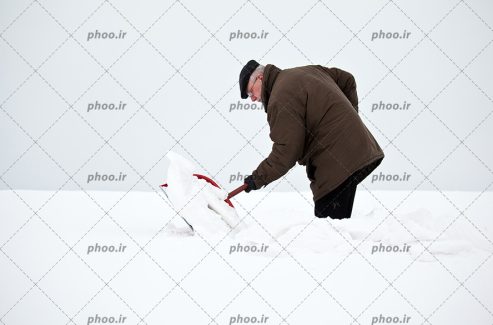 عکس مرد در حال از بین بردن برف با یک بیل پلاستیکی