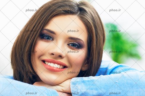 عکس با کیفیت چهره زن جوان با لبخند و چشم های آبی