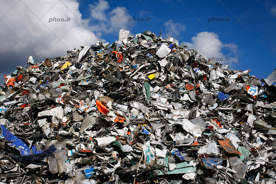 عکس تپه ای از آشغال ها و زباله ها با آسمان آبی