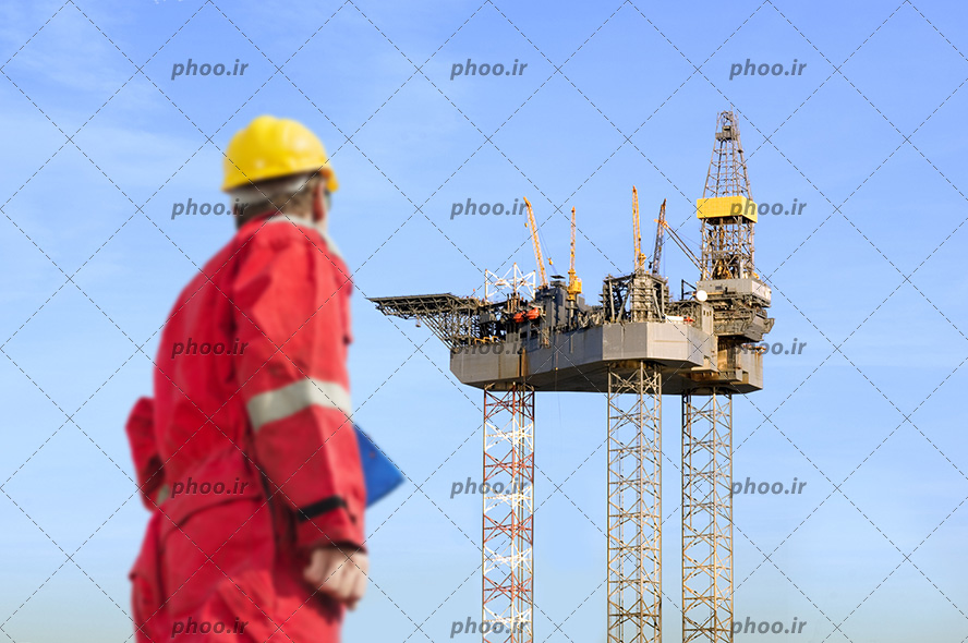 عکس یک مهندس در حال تماشای دکل نفتی عظیمی که ساخته شده است