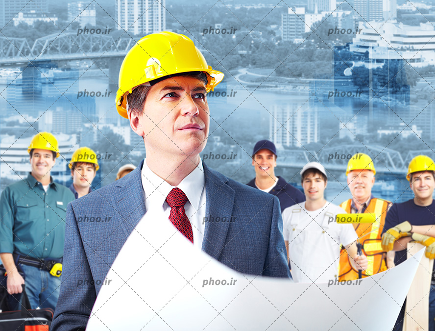 عکس مهندس ساختمان با کلاه ایمنی و نقشه در دست و کارگران ایستاده در پشت او