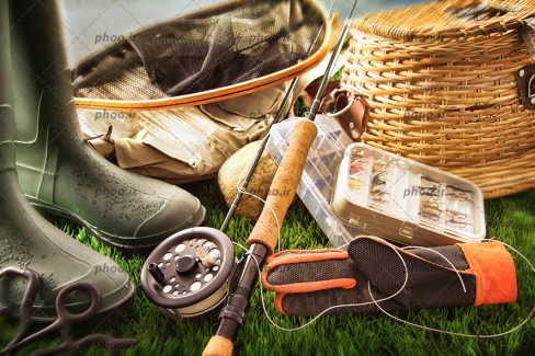 عکس با کیفیت وسایل ماهیگیری روی پس زمینه چمن های سبز