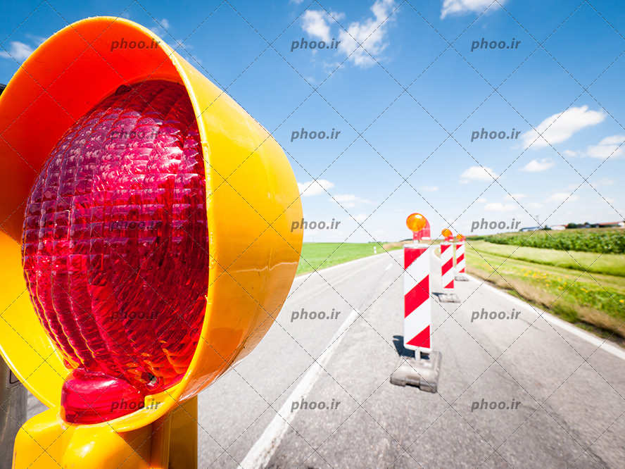 عکس با کیفیت تابلو های راهنمایی و رانندگی با چراغ های چشمک زن در جاده و آسمان آبی