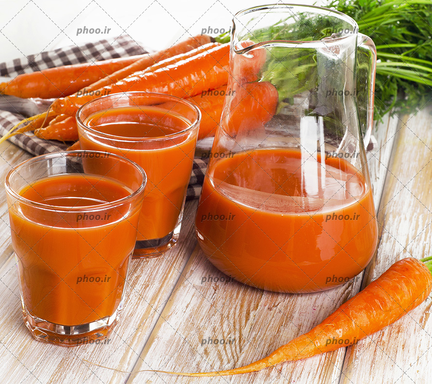 عکس آبمیوه هویج داخل دو لیوان بزرگ و پارچ کنار هویج ها
