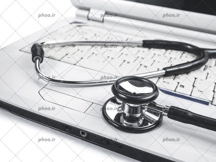 عکس گوشی پزشکی گذاشته شده روی لپ تاپ