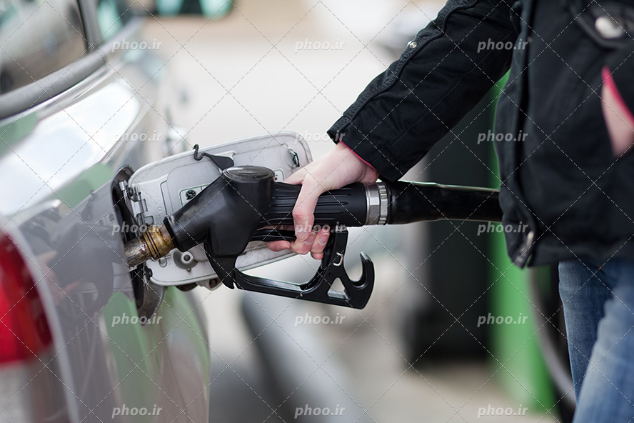 عکس با کیفیت دستان مرد در جیب کت مشکی و ایستاده در حال سوخت گیری
