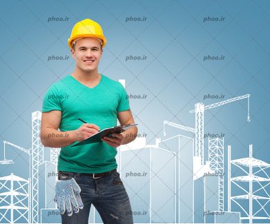 عکس مهندس مرد با لبخند با کلاه ایمنی و کلیپ بورد در مقابل یک طرح ساختمانی