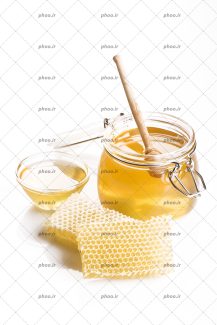 عکس عسل داخل ظرف و روی زمین و قاشق چوبی عسل داخل آن