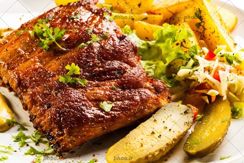 عکس سینه مرغ کبابی در کنار خیارشور و سیب زمینی سرخ شده
