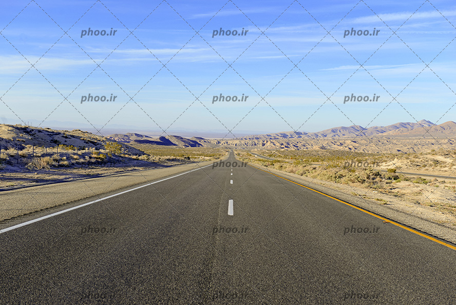 عکس با کیفیت جاده ای صاف در بیابان در مقابل آسمانی آبی
