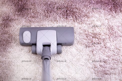 عکس جارو برقی کشیدن فرش از نمای نزدیک