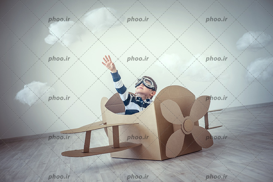 عکس با کیفیت از کودک خلبان در هواپیمای مقوایی