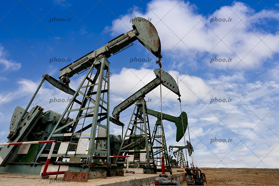 عکس سکوهای نفتی در بیابان در برابر آسمان آبی