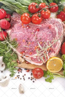 عکس گوشت خام در کنار ادویه و سبزیجات از نمای بالا در پس زمینه سفید