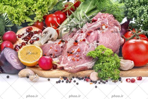 عکس گوشت خام در کنار ادویه و سبزیجات تازه در پس زمینه سفید
