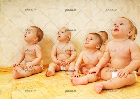 عکس با کیفیت گروهی از کودکان نوپا نشسته در حال نگاه کردن به چیزی