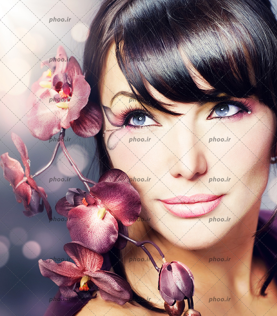 عکس خانم با آرایش صورت زیبا در کنار گل های ارکیده