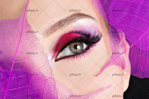 عکس خانم با آرایش چشم به رنگ صورتی و برگ های صورتی روی صورتش