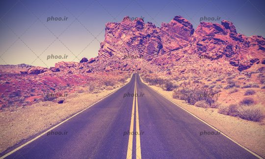 عکس جاده ای در بیابان در پس زمینه کوه