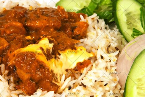 عکس غذای برنجی با خورشت روی آن