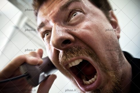 عکس مرد درحال داد زدن پشت تلفن