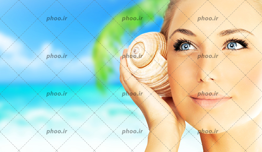 عکس زیبا خانم گوش کردن صدای داخل صدف در دست درکنار دریا