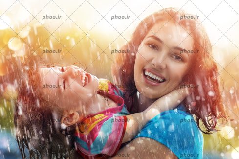عکس با کیفیت مادر و دختر زیبای شاد زیر باران از نمای نزدیک