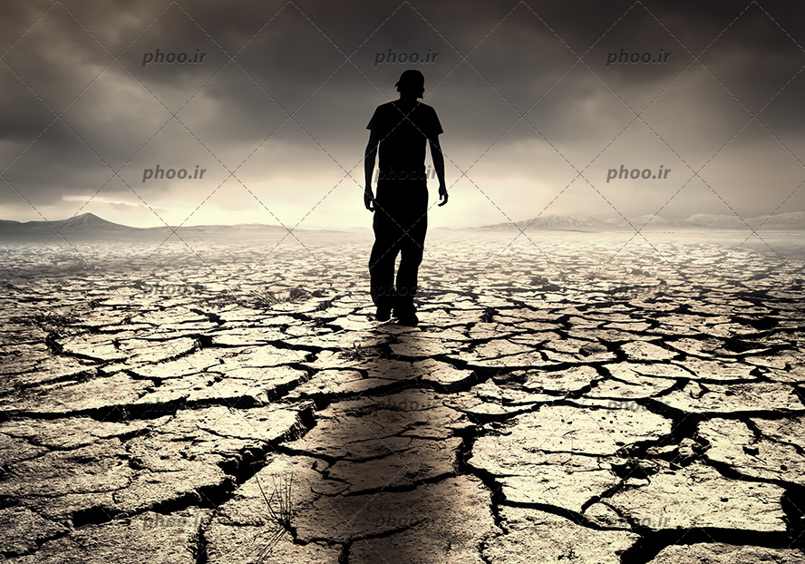 عکس با کیفیت یک مرد جوان که در صحرا متروک راه می رود