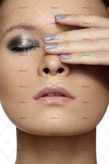 عکس پرتره زیبا مدل زن با پوست سالم و آرایش نقره ای چشم و مانیکور خاکستری است