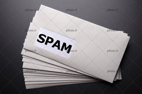 عکس پاکت های نامه و نوشته انگلیسی(spam) روی آن در پس زمینه مشکی