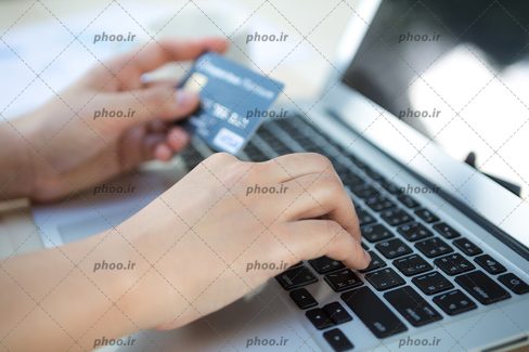 عکس با کیفیت مرد با کارت اعتباری در دست در حال پرداخت آنلاین با لپ تاپ