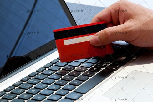 عکس با کیفیت کارت اعتباری در دست در حال پرداخت آنلاین با لپ تاپ