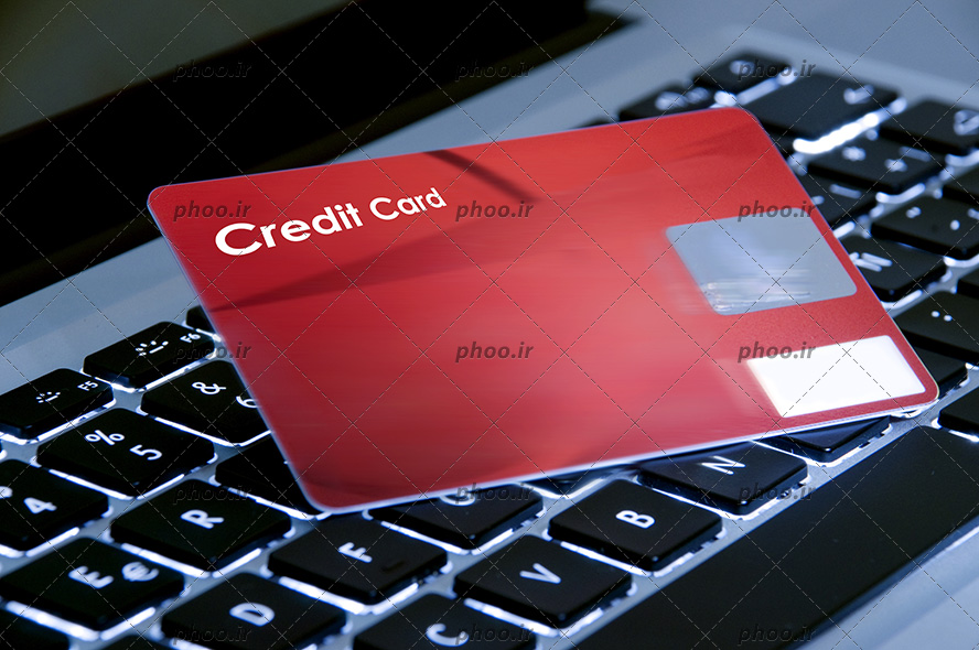 عکس با کیفیت کارت اعتباری قرمز روی کیبورد لپ تاپ
