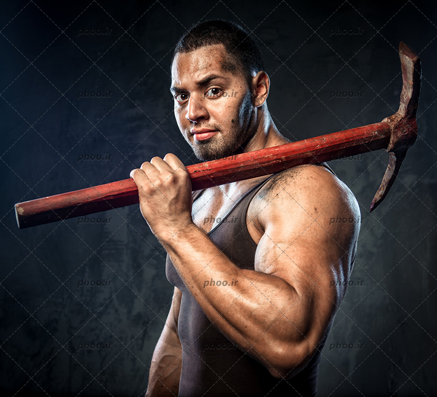 عکس مرد قوی که کلنگ در دست دارد در پس زمینه مشکی