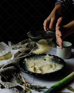 عکس الک کردن آرد در ظرف مشکی و تم مشکی
