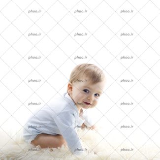 عکس با کیفیت کودک زیبا با لبخند نشسته در پس زمینه سفید