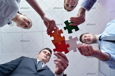 عکس با کیفیت نمای پایین از مردم تاجر در حال گذاشتن تکه های پازل در کنار هم