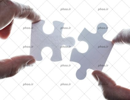 عکس با کیفیت قرار دادن دو قطعه پازل در کنار هم در پس زمینه سفید