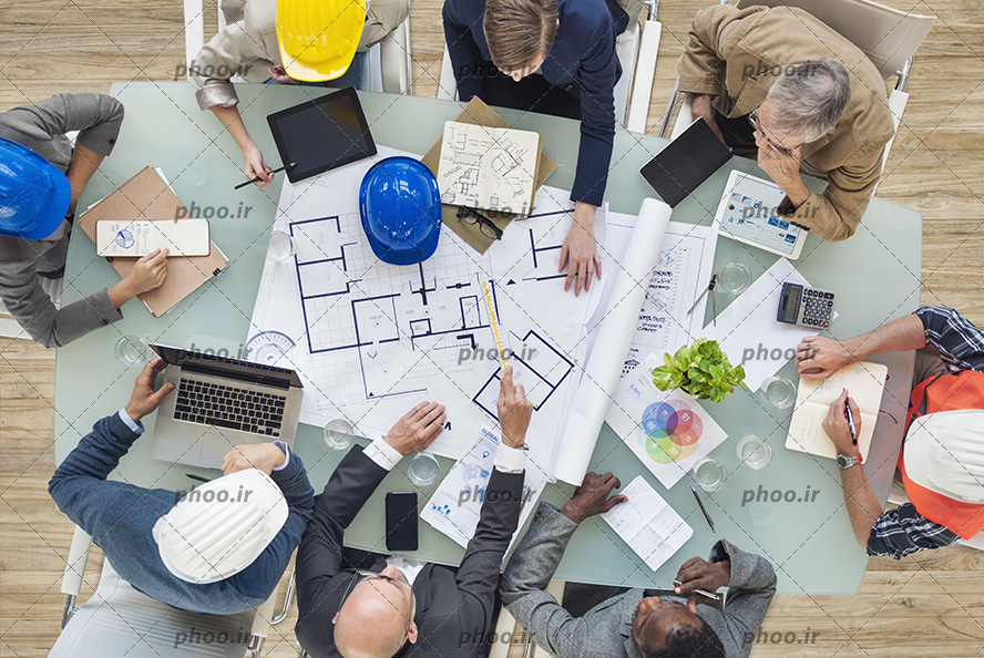 عکس زیبا کار کردن مهندسان سر میز با لب تاپ و مداد نقشه