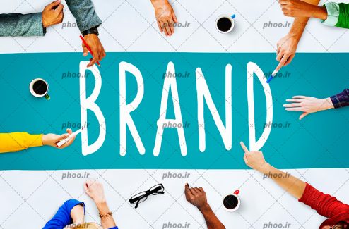 عکس کلمه انگلیسی (brand) در پس زمینه آبی و دست های اطراف آن در حال بحث و گفت و گو درباره آن