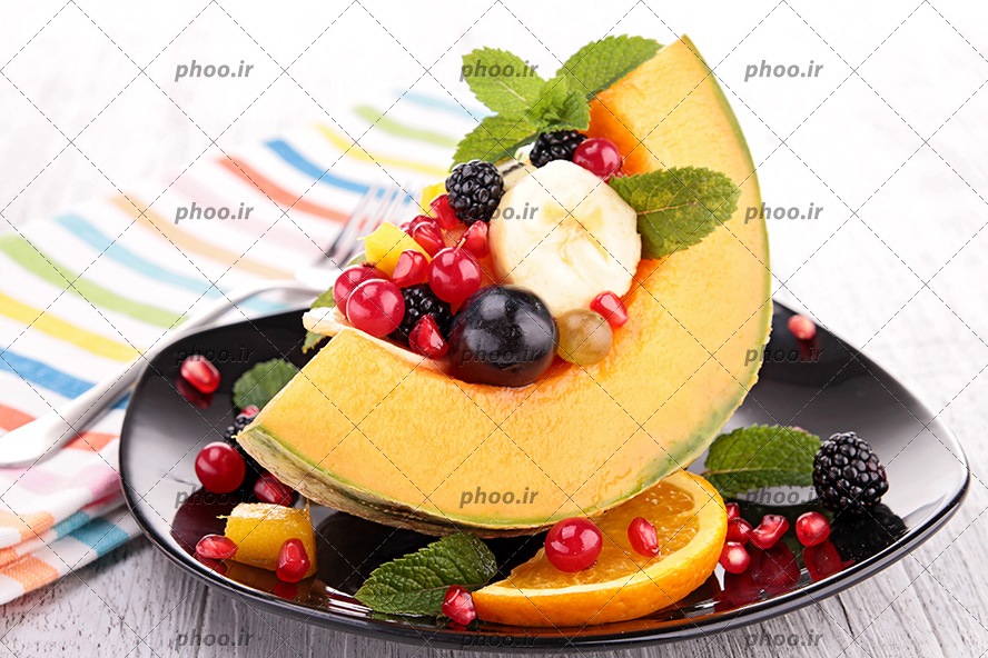 عکس سالاد میوه روی خربزه در ظرف مشکی