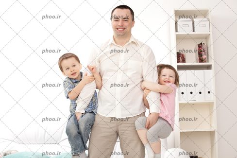 عکس پدر جوان شاد در حال بازی با بچه ها در خانه