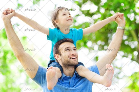 عکس با کیفیت پسر بر روی دوش پدر در حال نگاه کردن به چیزی در فضای باز