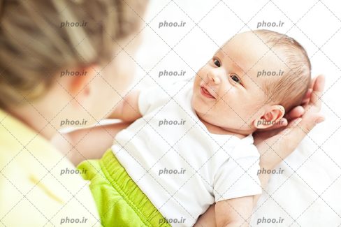 عکس با کیفیت مادر در حال صحبت کردن با نوزاد بانمک در پس زمینه سفید