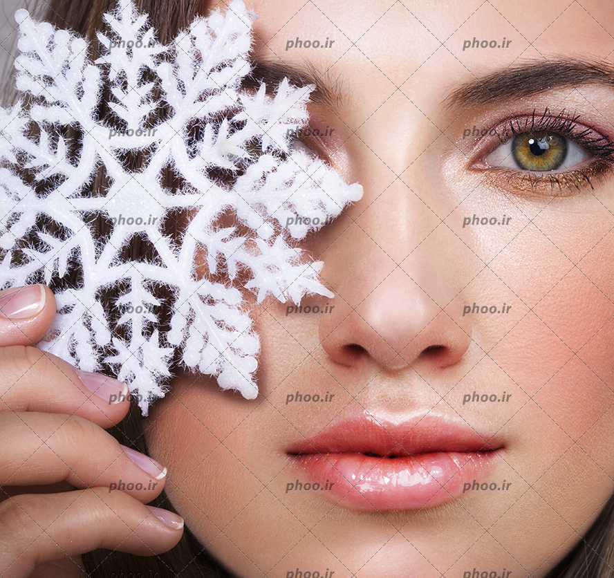 عکس یک خانم با آرایش زیبا و گرفتن یک دونه برف روی یک چشم