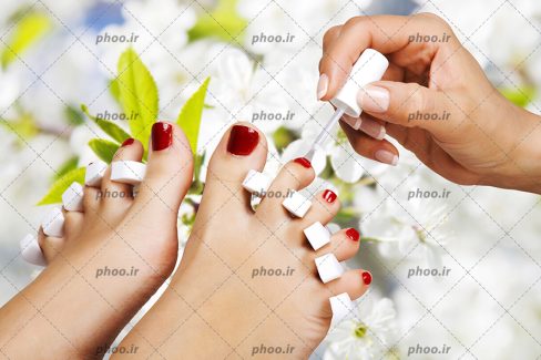 عکس خانم در حال لاک زدن ناخن پا در سالن آبگرم در باغ
