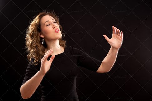 عکس رهبر گروه کر زن در حین اجرا در پس زمینه مشکی