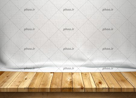 عکس میز چوبی در پس زمینه پارچه سفید